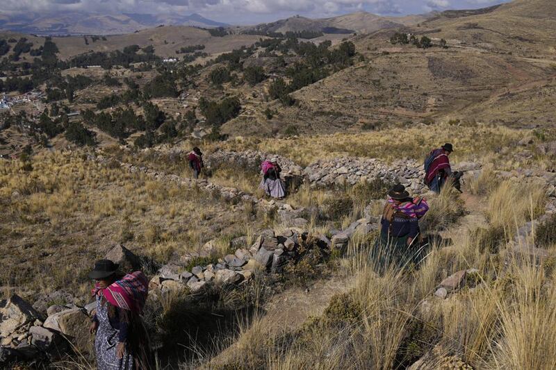 Mujeres indígenas aymaras rezan en un llamado a la lluvia en la montaña sagrada Inca Pucará en Chiquipata, Bolivia, el miércoles 16 de noviembre de 2022. (AP Foto/Juan Karita)