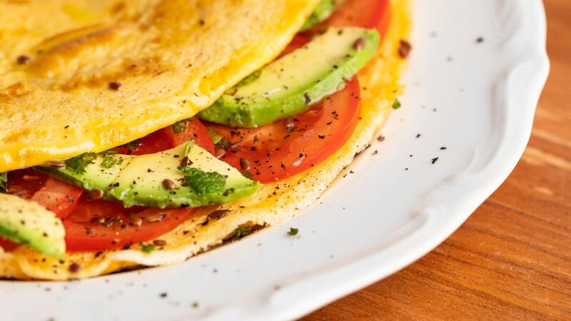 Close-up de tortilla con tomate y aguacate en placa