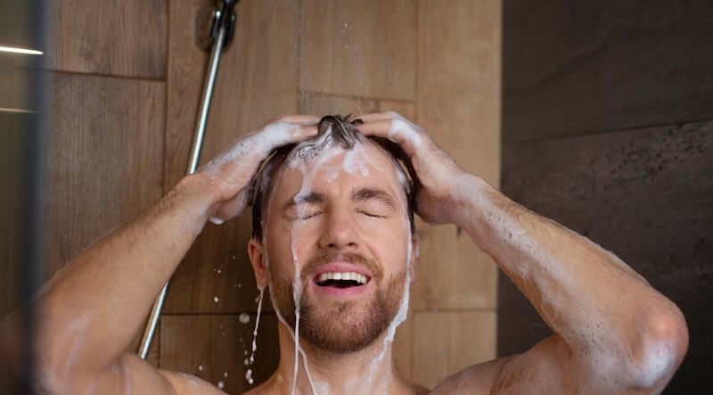 Vista frontal hombre lavando el cabello