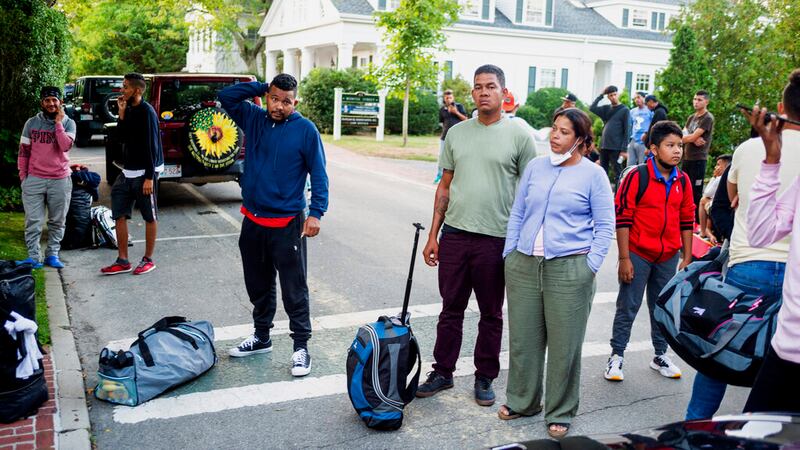 Migrantes que llegaron en un vuelo enviado por el gobernador de Florida, Ron DeSantis, se reúnen con sus pertenencias frente a la Iglesia Episcopal de St. Andrews, el miércoles 14 de septiembre de 2022, en Edgartown, Massachusetts, en Martha's Vineyard.