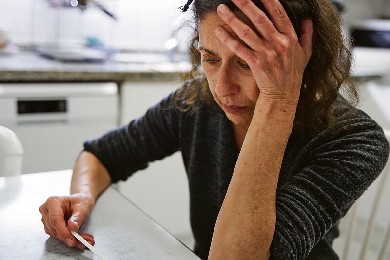 Una mujer se muestra devastada y triste después de tener un resultado positivo a covid-19 con un aprueba casera.