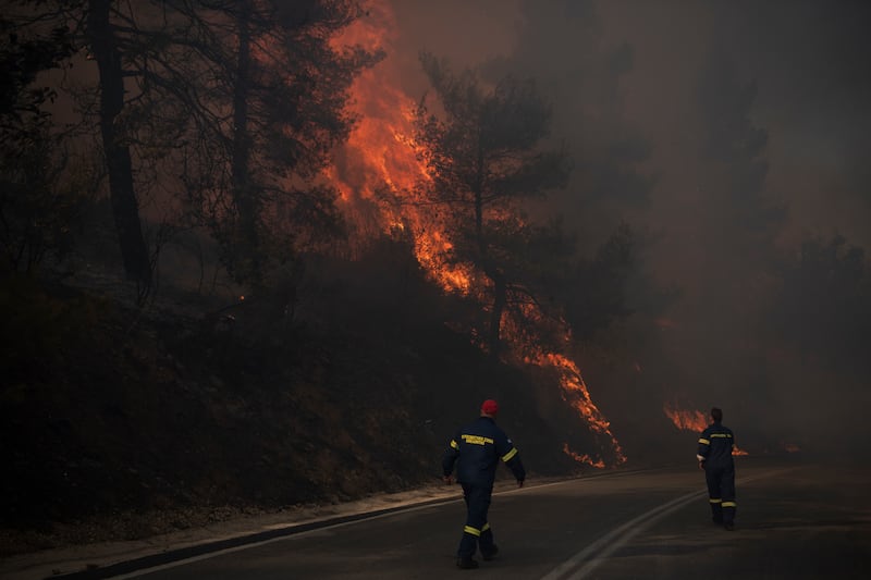 Bomberos inspeccionan las llamas cerca de una carretera en Varnava durante un incendio forestal, al norte de Atenas, Grecia, el domingo 11 de agosto de 2024. (Foto AP/Michael Varaklas)