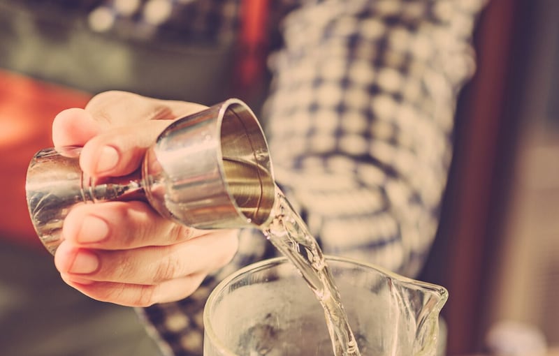 Barman haciendo un cóctel alcohólico en el mostrador del bar