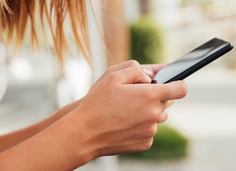 Mujer joven con smartphone negro