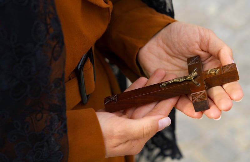 Mujer sosteniendo un crucifijo en la iglesia